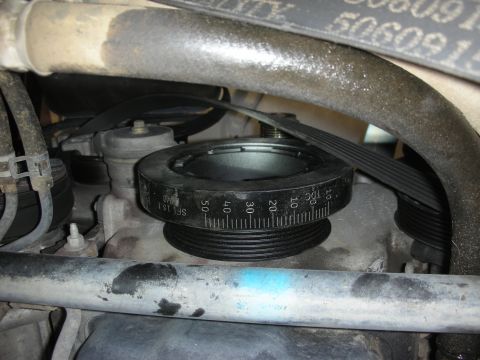 2004 Ford Crown Victoria - Engine pulley with degree markings and a timing belt visible.