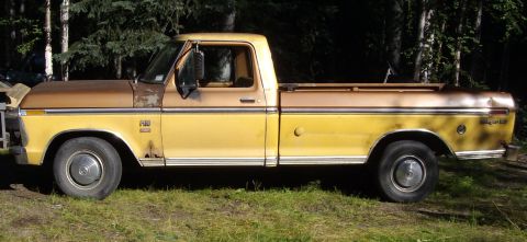 1976 Ford F-150 - This classic pickup truck features a two-tone paint scheme and is seen from the side in an outdoor setting.