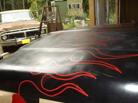 1978 Ford Bronco - Hood with flame decals, with a brown truck visible behind it.