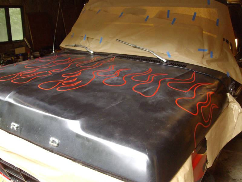 Ford hood with red flame decals, windshield wipers, and masking paper over windshield