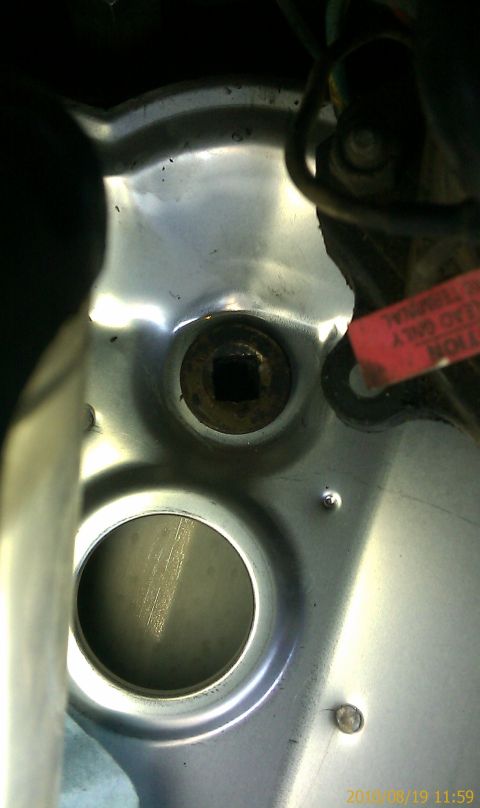 1985 Ford F-150 - A close-up view of an engine component, a square bolt head and a circular opening. A red tag is also visible.