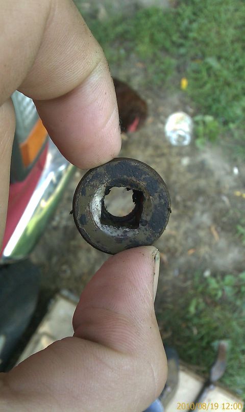 1985 Ford F-150 - A rubber grommet with a square hole is held between fingers, with chrome trim visible on the left.