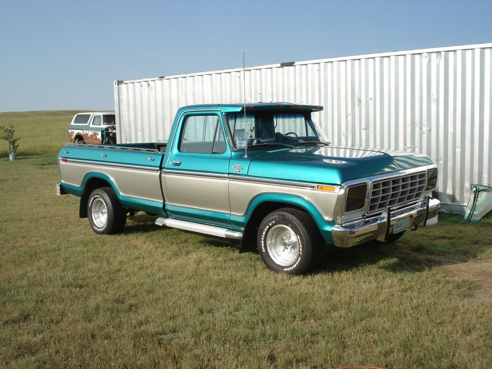 1979 Ford F-150 pickup truck, teal and tan two-tone paint, chrome bumper, parked on grass