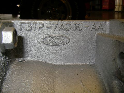 1990 Ford Bronco - Close-up of a Ford transmission part showing the Ford logo and casting numbers F3TP-7A039-AA.