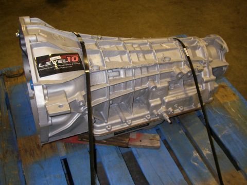 1990 Ford Bronco - A rebuilt transmission sits on a blue pallet, secured with black straps.