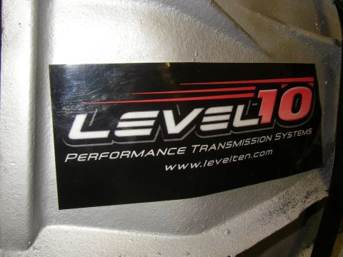 1990 Ford Bronco - Close-up of a sticker on a transmission housing for Level 10 Performance Transmission Systems.