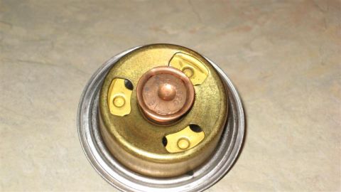 1968 Ford Ranchero - Thermostat part with visible markings, likely for a vehicle cooling system.