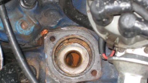 1968 Ford Ranchero - Close-up of an engine block's thermostat housing mounting area, showing rust and corrosion.