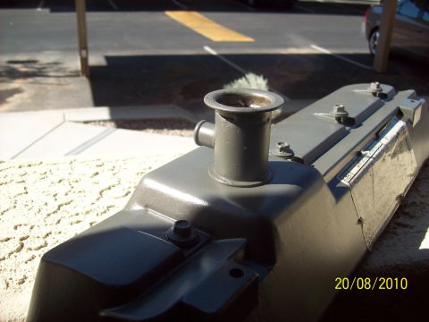 1985 Ford Bronco - A gray radiator part is shown outdoors, with a date stamp and website visible on the side.