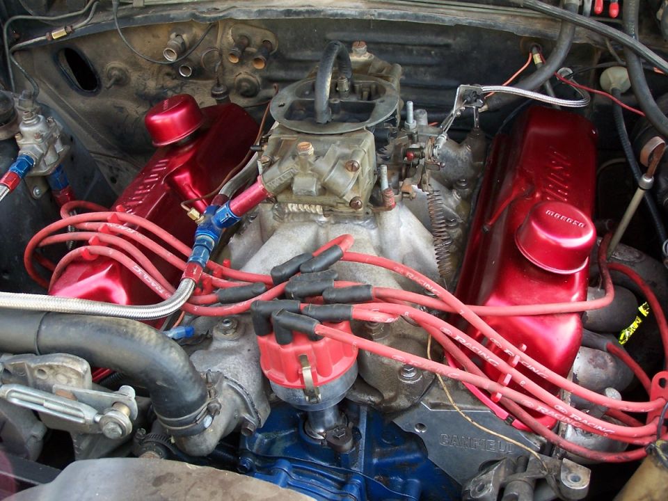 Close-up of a V8 engine with red valve covers and spark plug wires