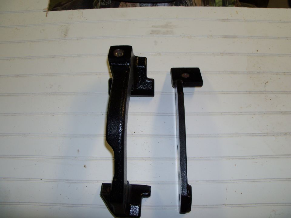 Stock bracket is left fabricated is on right.  The fabbed bracket is made with 3/8" x 2" mild steel with a 1/4" x 1 1/2" spacer welded and tapped for lower mounting hole. An additional brace (1/4" x 3/4") will be positioned between caliper bracket bolt holes for additional strength