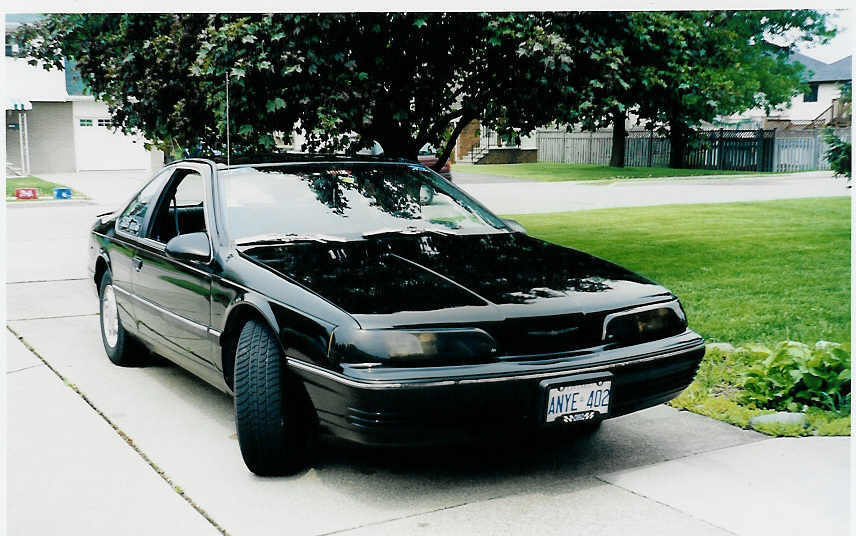 Black 1990 Ford Thunderbird coupe parked on driveway