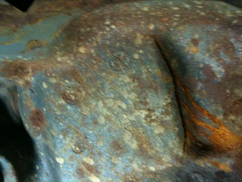 1993 Ford Bronco - Close-up of a corroded metal component, likely from a vehicle's undercarriage.