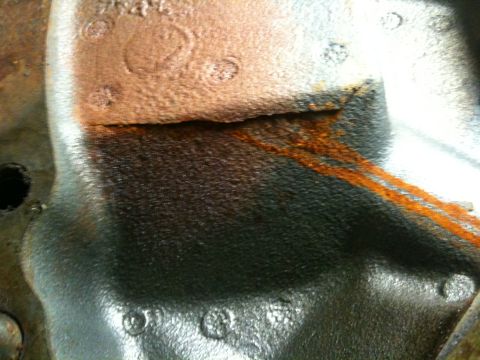1993 Ford Bronco - Detail of a heavily rusted metal component, possibly from a transmission donor truck.