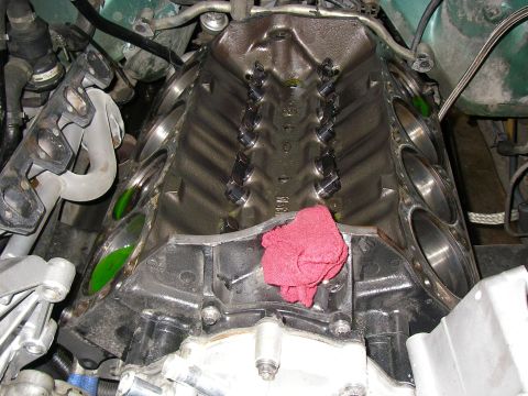 1990 Ford Bronco - A close-up looking down into the lifter valley of a V8 engine with the intake manifold removed, exposing two rows of valve lifters and push…