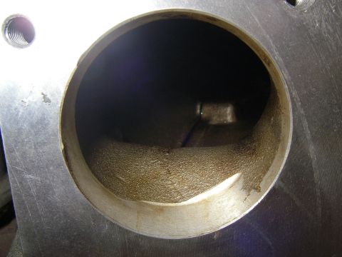 1990 Ford Bronco - Close-up looking straight down a machined throttle body or intake bore, showing the smooth polished upper lip and a rougher cast, ported pa…