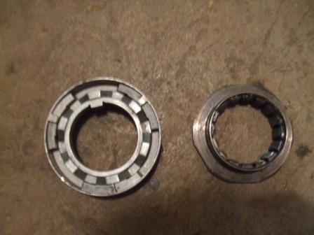 1996 Ford Bronco - Two metal bearing parts are shown on a textured surface.