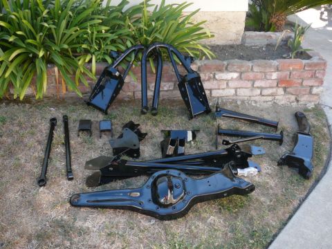 1988 Ford Bronco - Various black vehicle suspension parts and a differential are displayed on the ground.
