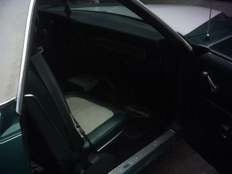 1977 Ford Ranchero - The interior of a vehicle is shown, a seat and dashboard with a Harley-Davidson mat on the floor.