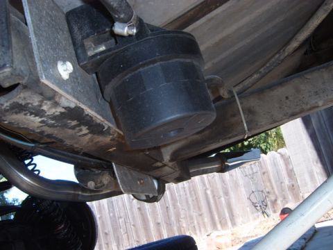 1973 Ford Ranchero - Close-up of a vehicle's undercarriage, focusing on a black component and suspension parts.