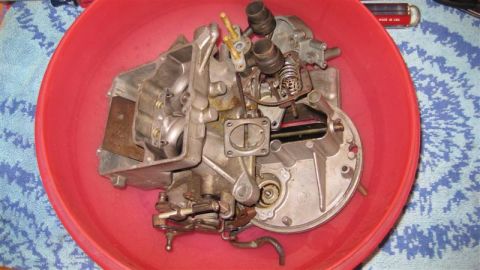 1968 Ford Ranchero - Disassembled carburetor sits in a red bowl, ready for cleaning or reassembly.