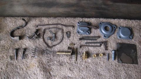 1968 Ford Ranchero - Various disassembled carburetor components are arranged on a textured mat, suggesting a repair or rebuild process.