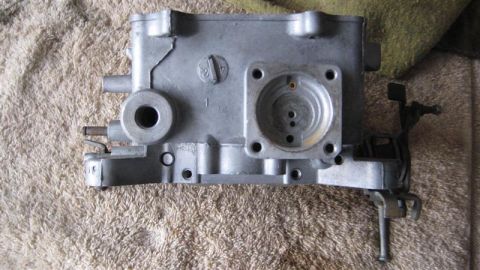 1968 Ford Ranchero - A metal carburetor is shown from a top-down perspective on a textured background.