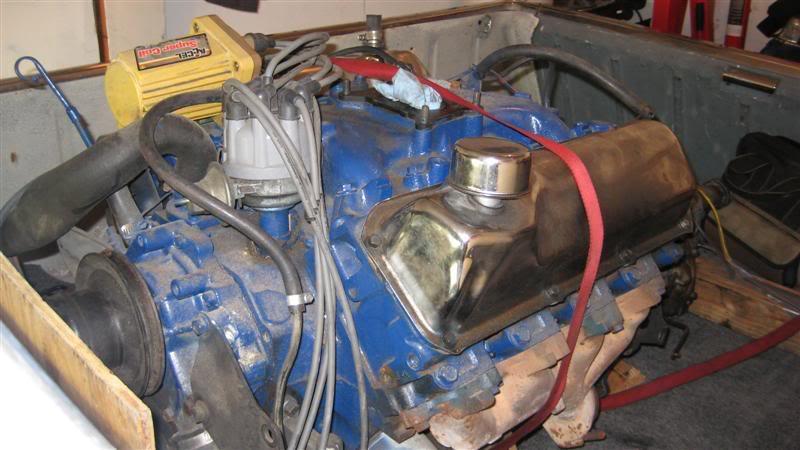 Blue V8 engine with chrome valve covers and a yellow ignition coil