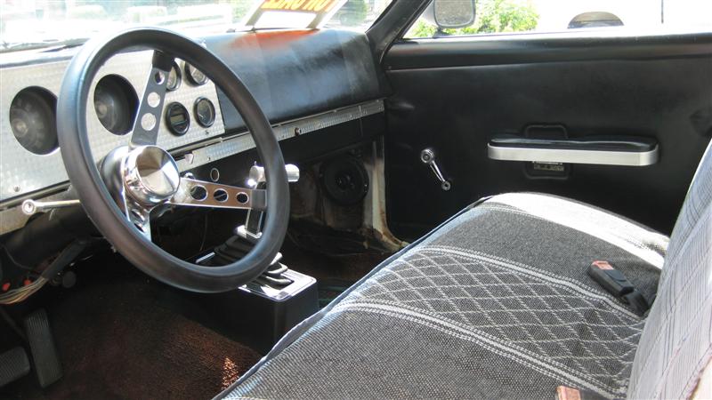 Car interior with aftermarket steering wheel, diamond-patterned seat, and door panel