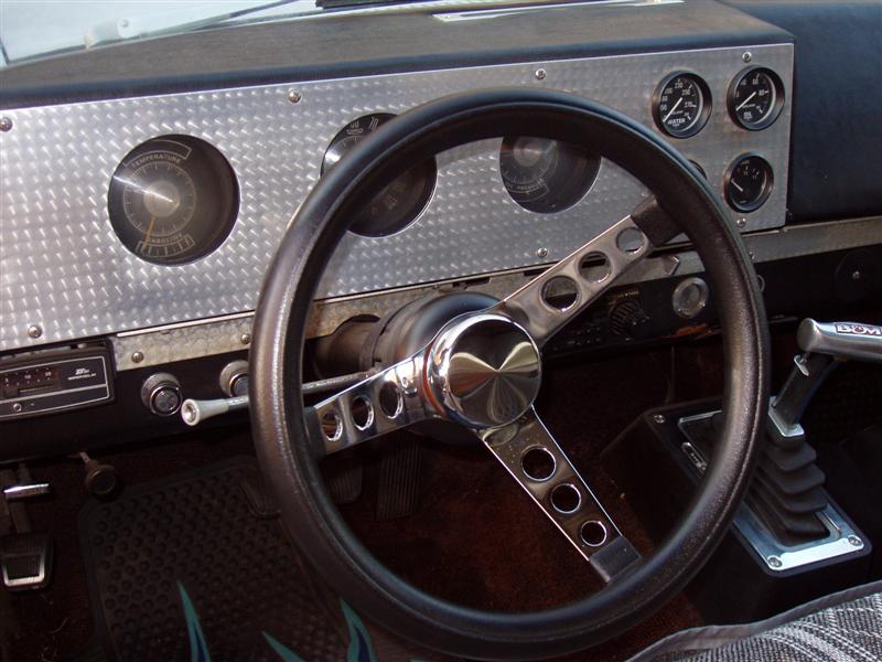 vehicle interior with custom diamond plate dash, aftermarket steering wheel, and gauges