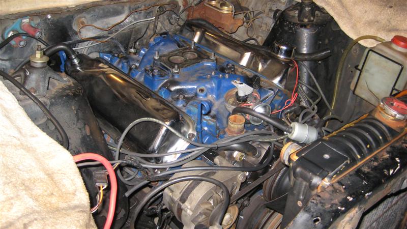 engine bay with blue intake manifold, chrome valve covers, and various hoses and wires