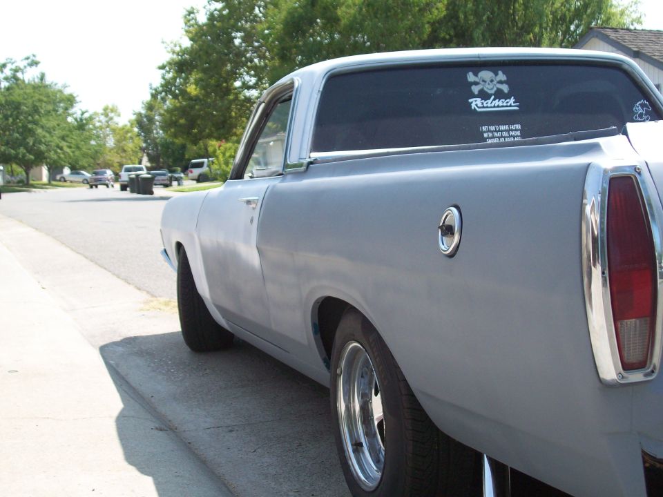 Primer-gray Ford Ranchero rear 3/4 view with chrome trim and Redneck decal on rear glass