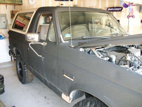1990 Ford Bronco - This 1990 Ford Bronco is shown from a 3/4 front angle, with the hood open revealing the engine.