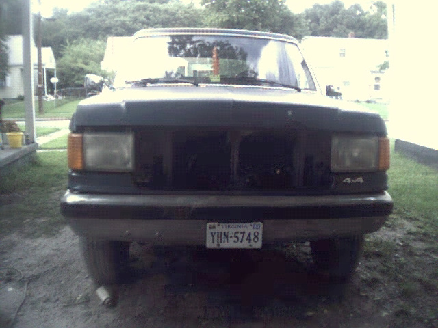 Dark SUV with missing grille, front view. License plate reads YHN-5748