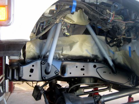 1996 Ford Bronco - Vehicle frame and suspension parts are being painted, with masking paper protecting other components.