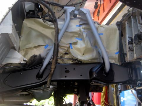 1996 Ford Bronco - Close-up view of vehicle frame and suspension components, some parts are masked off with paper and tape.