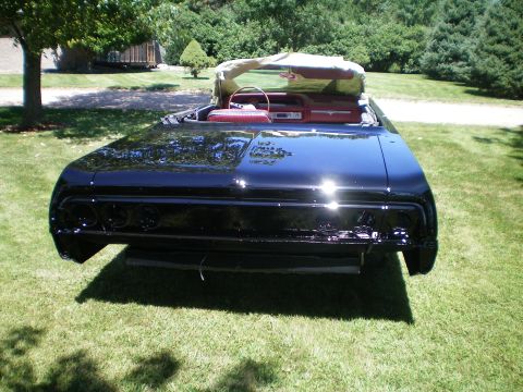 1964 Chevrolet Impala - Rear view of a black 1964 Chevrolet Impala convertible with its top up and red interior.
