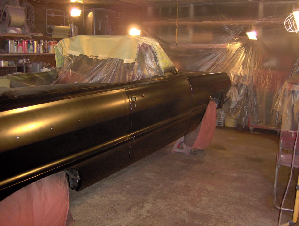 1964 Chevrolet Impala side view, covered in plastic for painting in a garage