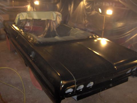 1964 Chevrolet Impala - A black 1964 Chevrolet Impala convertible is being worked on in a spray booth.