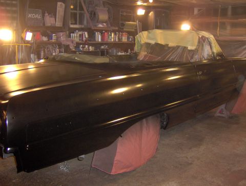 1964 Chevrolet Impala - A black 1964 Chevrolet Impala convertible is being worked on in a garage, with its interior covered for paint protection.