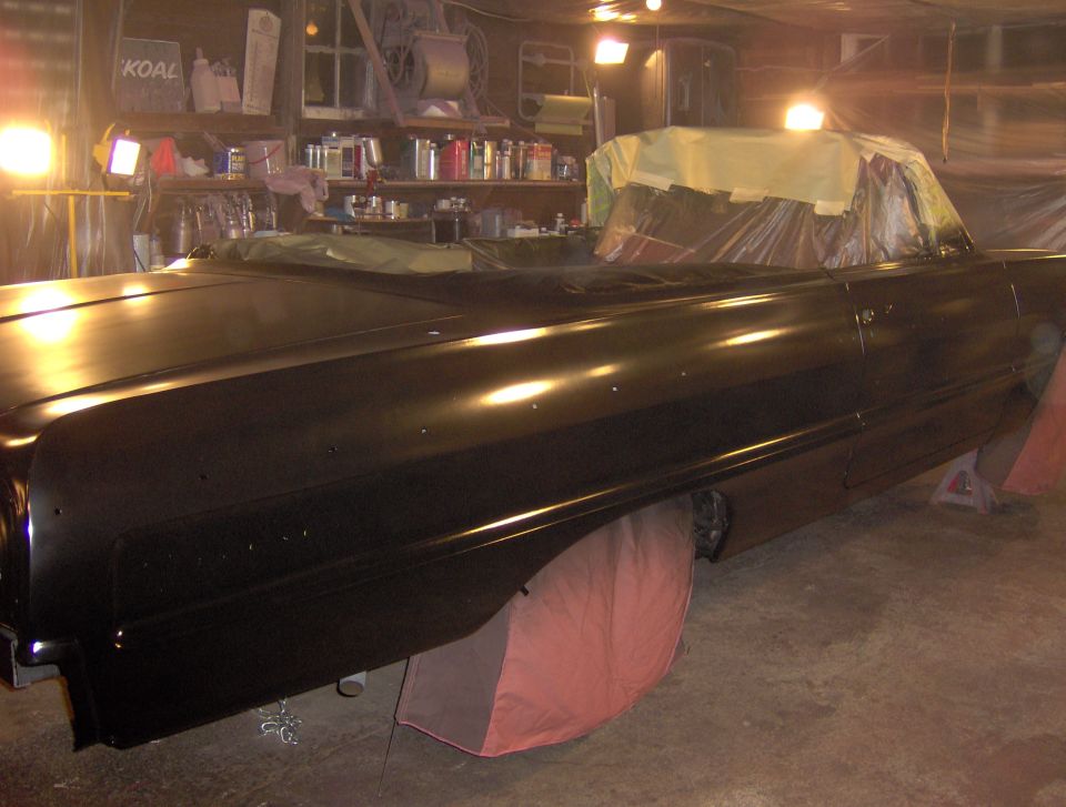 Black 1964 Chevrolet Impala convertible on jack stands, interior masked for painting