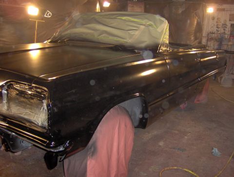 1964 Chevrolet Impala - A black 1964 Chevrolet Impala is seen in a paint booth, with parts of it covered by a tarp.