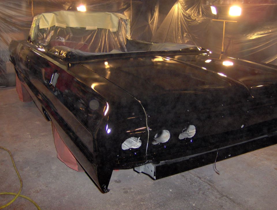 Black 1964 Chevrolet Impala convertible undergoing paintwork, rear quarter view