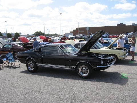 1968 Shelby GT500 - A black 1968 Shelby GT500 is displayed with its hood open at an outdoor car show.