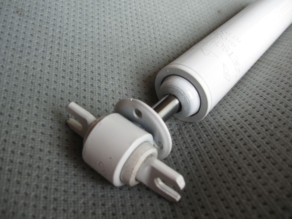 Close-up of a white shock absorber with a mounting bracket