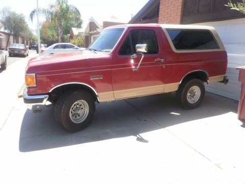 1991 Ford Bronco - This 1991 Ford Bronco is shown from the side, a two-tone red and tan paint scheme.