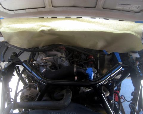 1996 Ford Bronco - The engine bay shows an aftermarket brace, with some components covered by protective paper.