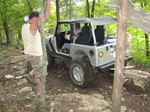 2005 Jeep Wrangler - A silver 2005 Jeep Wrangler navigates a challenging rocky terrain during an off-road excursion.