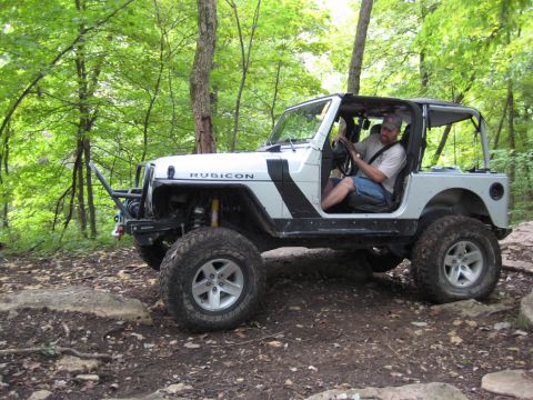 2005 Jeep Wrangler - White 2005 Jeep Wrangler Rubicon navigating a rocky trail in a wooded area.