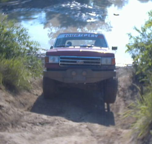 Red 1989 Ford Bronco front view off-roading